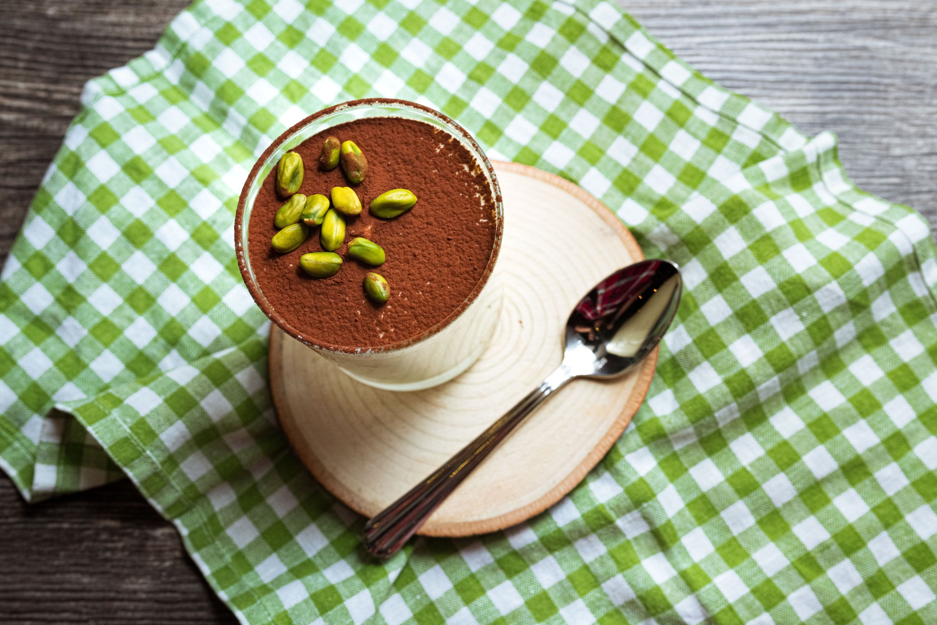 Dessert tiramisu with pistachios sprinkled with cocoa powder. View from slightly above.